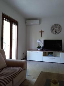 - un salon avec une télévision et une croix sur le mur dans l'établissement Villa Mia Ana, à Međugorje