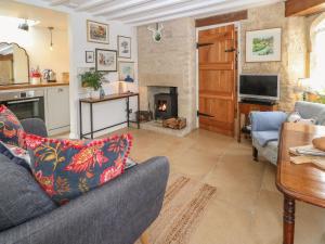 a living room with a couch and a fireplace at Butterrow Gate in Stroud