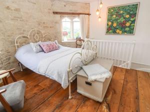 1 dormitorio con 1 cama y una pintura en la pared en Butterrow Gate, en Stroud