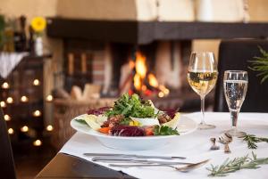 a plate of salad and a glass of wine on a table at Ferienwohnung Harmonie in Boltenhagen