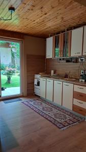 une cuisine avec des placards blancs et une grande fenêtre dans l'établissement Cabana Mistic, à Bran