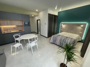 1 dormitorio con 1 cama, mesa y sillas en Apartamentos Aljama en Burgos