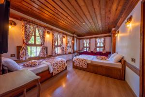 1 dormitorio con 2 camas y techo de madera en Cesmeli Konak Garden, en Safranbolu