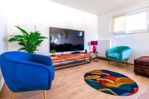 sala de estar con silla azul y sofá en L'Ardenne de Fidéline, en Tenneville
