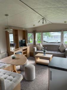 ein Wohnzimmer mit einem Sofa und einem Tisch in der Unterkunft Holiday home at Parkdean Cherry Tree Holiday Park 627 in Great Yarmouth