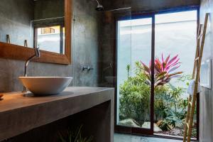 a bathroom with a sink and a large window at Vila de Charme in São Miguel do Gostoso