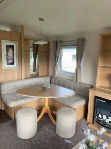 ein Wohnzimmer mit einem Tisch und einem Sofa in der Unterkunft Holiday home at Parkdean Cherry Tree Holiday Park 627 in Great Yarmouth