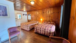 A bed or beds in a room at Pine Cone Motel