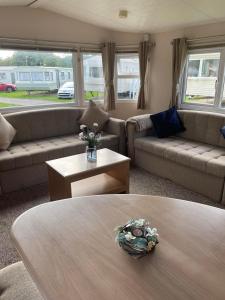 a living room with couches and a coffee table at Holiday home at Parkdean Cherry Tree Holiday Park 627 in Great Yarmouth