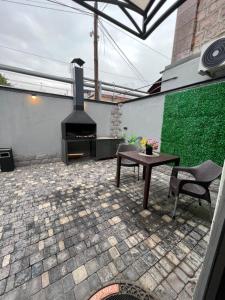 a patio with a fireplace and a table at ROMANTIC ATMOSPHERE Self Check In in Yerevan