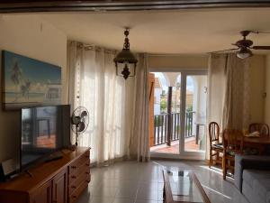 a living room with a flat screen tv and a table at Las tres palmeras in Vinarós