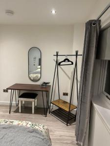 1 dormitorio con mesa, espejo y escritorio en Chieftain’s Cabin en Kensaleyre
