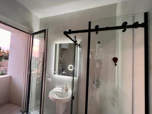 uma casa de banho com um chuveiro e um lavatório. em Kino Apartment em Tirana