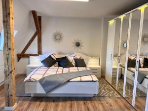 ein Schlafzimmer mit einem weißen Bett mit Spiegeln an der Wand in der Unterkunft Apartment Kander in Görlitz