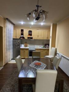 a kitchen with a wooden table and white chairs at Nena in Veliko Gradište