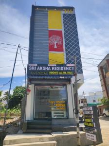 a building with a sign in front of a store at Sri Aksha Residency in Alāndurai