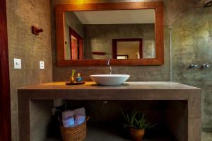 ein Bad mit einem Waschbecken und einem Spiegel in der Unterkunft Vila de Charme in São Miguel do Gostoso