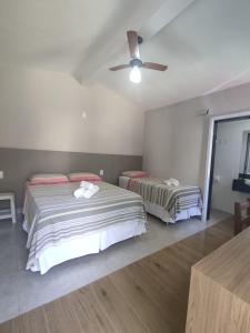 1 Schlafzimmer mit 2 Betten und einem Deckenventilator in der Unterkunft Vila da Praça Pousada in Capitólio