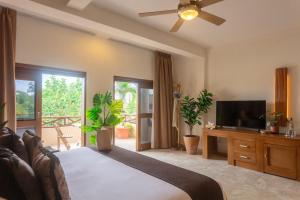 a bedroom with a bed and a flat screen tv at Hotel Arena in Holbox Island