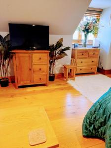 una sala de estar con TV en un tocador de madera en Pinecroft Barn - Relax & Unwind! en Storrington