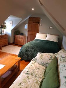 een slaapkamer met een bed en een bank erin bij Pinecroft Barn - Relax & Unwind! in Storrington