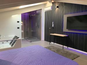 a bedroom with a large purple bed and a tv at Villa Primodì in Bologna