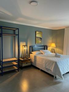 a bedroom with a large bed and two night stands at Hotel Caieiras in Guaratuba