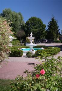 einen Brunnen inmitten eines Parks mit Blumen in der Unterkunft Ferienwohnung Sophia in Boltenhagen