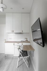 eine weiße Küche mit einem Tisch und einem Spiegel in der Unterkunft Angel House Vilnius, 46 in Vilnius