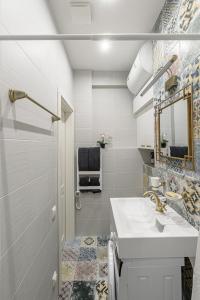 ein weißes Badezimmer mit einem Waschbecken und einem Spiegel in der Unterkunft Angel House Vilnius, 46 in Vilnius
