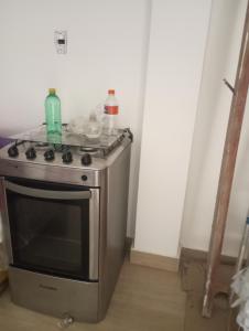 a small stove with two bottles on top of it at Apartamento Flat in Anápolis