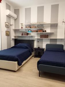 1 dormitorio con 2 camas, mesa y estanterías en AURY HOUSE - STATlON - -ViaDante-Platani- en Cremona