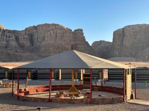 ein Zelt in der Wüste mit Bergen im Hintergrund in der Unterkunft Mountain Magic Camp Wadi Rum in Wadi Rum