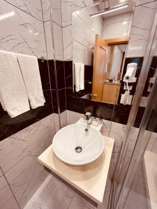 a bathroom with a white sink and a shower at Lily Rooms in Istanbul