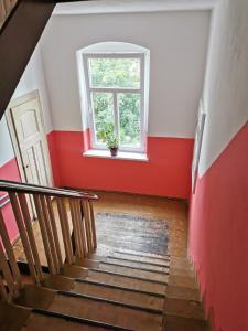 een trap met een rode muur en een raam bij Studio Isabel Cieplice in Jelenia Góra