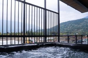 a hot tub in a building with a large window at RevelStoked Getaway by Revelstoke Vacations in Revelstoke