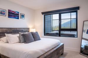 a bedroom with a large bed and a window at RevelStoked Getaway by Revelstoke Vacations in Revelstoke