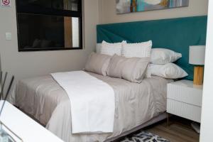 a bedroom with a bed with white sheets and pillows at Elegant-comfortable space-self checkin & FREE WIFI in Pretoria