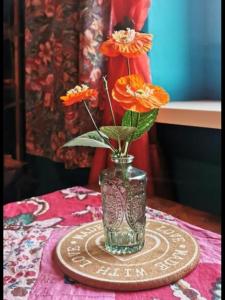 een vaas met oranje bloemen op een tafel bij Studio Isabel Cieplice in Jelenia Góra