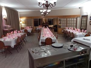 un comedor con mesas y sillas rosas en mountain shadows hotel, en Elliot