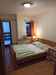 een slaapkamer met een bed en 2 ramen bij Pokoje, kwatery prywatne przy stoku w Zieleńcu in Duszniki Zdrój