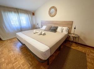 1 dormitorio con 1 cama grande y toallas. en AZ El Balcón a la Basílica I - vistas inmejorables a la Basílica del Pilar!, en Zaragoza