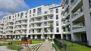 a large white apartment building with a courtyard at Apartament Mono Ełk CENTRUM in Ełk