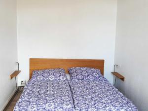 a bedroom with a bed with blue and white sheets at Ferienwohnungen direkt am See in Ventschow