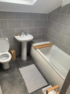een badkamer met een wastafel, een bad en een toilet bij Cosy Cottage, Nr Betws y Coed. in Llanrwst