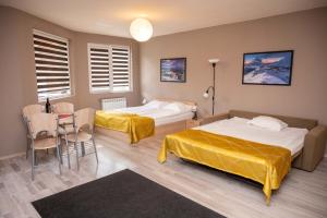 a hotel room with two beds and a table and chairs at All Seasons Apartments Iglika 2 in Borovets