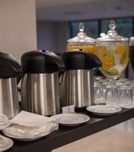 two kettles on a counter with plates and glasses at Comfort Hotel Presidente Prudente in Presidente Prudente +46 photos