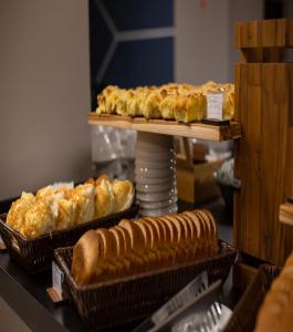 a display of bread and pastries on a table at Comfort Hotel Presidente Prudente in Presidente Prudente