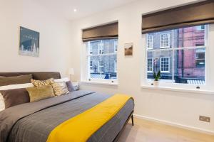 a bedroom with a bed and two windows at Welcome London Seven Dials in London