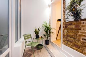 a room with two chairs and a glass table with plants at Welcome London Seven Dials in London